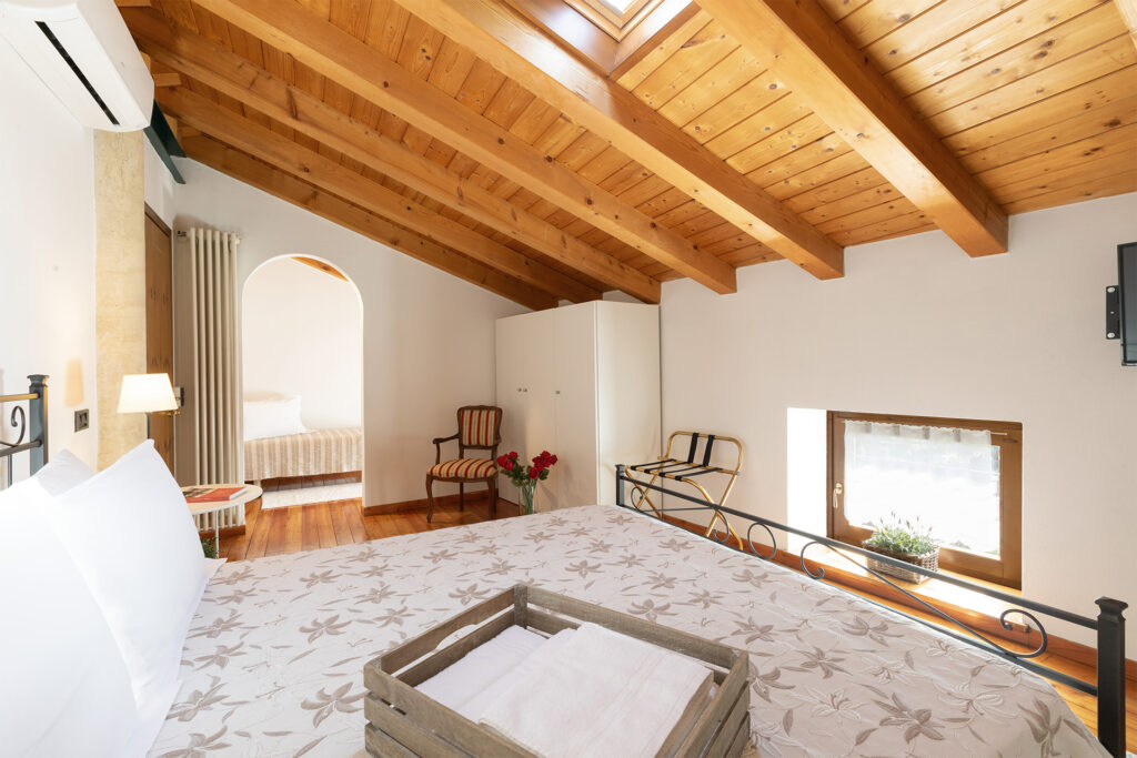 Camera La Torretta - camera con letto, armadio, finestra, tetto in legno